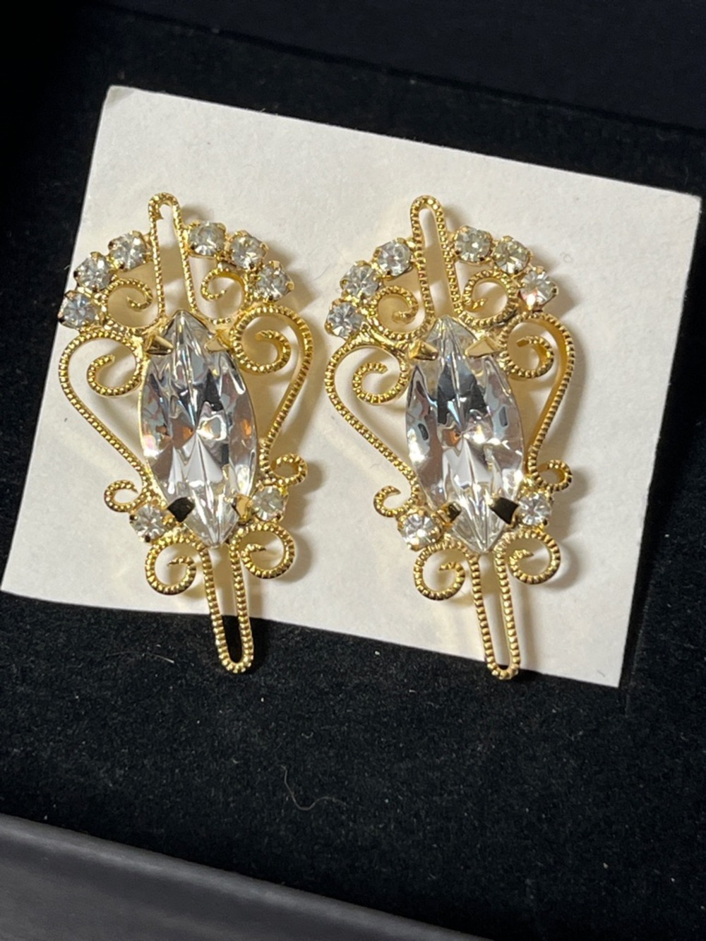 Vintage ornate gold-tone earrings with central marquise-cut rhinestones.